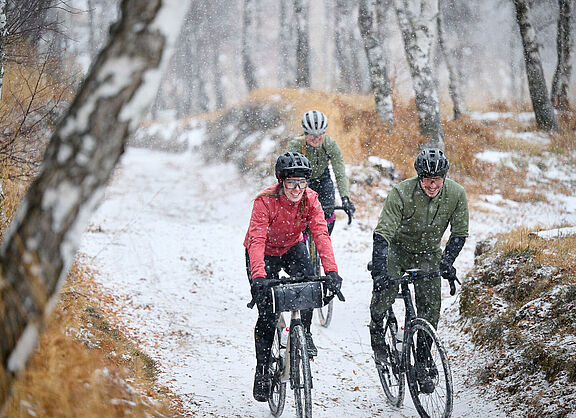 3 Radfahrer auf verschneiten Waldweg